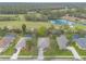 Aerial view of the neighborhood showcases homes, a pond, golf course, and lush trees at 2626 Turnbull Estates Dr, New Smyrna Beach, FL 32168