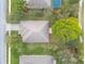 An aerial top-down shows a well-kept house and yard with mature trees lining the streets in a golf community at 2626 Turnbull Estates Dr, New Smyrna Beach, FL 32168