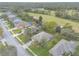 An aerial view shows a well-kept house and yard that backs onto a golf course in a desirable community at 2626 Turnbull Estates Dr, New Smyrna Beach, FL 32168