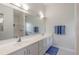 Bathroom with dual sinks, a large mirror, a shower and blue accents at 2626 Turnbull Estates Dr, New Smyrna Beach, FL 32168