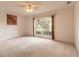 Bright bedroom features neutral carpet, large windows with backyard view, and ceiling fan at 2626 Turnbull Estates Dr, New Smyrna Beach, FL 32168