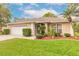 Charming single story home with lush landscaping, a well-manicured lawn, and attached two car garage at 2626 Turnbull Estates Dr, New Smyrna Beach, FL 32168