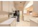 Well-lit kitchen with white cabinetry, modern appliances, tile floors and ample counter space at 2626 Turnbull Estates Dr, New Smyrna Beach, FL 32168