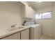 Well-lit laundry room featuring ample cabinet space, a large sink, and a washer/dryer at 2626 Turnbull Estates Dr, New Smyrna Beach, FL 32168