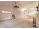 Bright living room features neutral carpet, ceiling fan, and seamless access to the kitchen at 2626 Turnbull Estates Dr, New Smyrna Beach, FL 32168
