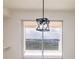 A modern pendant light hangs in front of a sliding glass door, with a balcony and a view beyond at 265 Minorca Beach Way # 505, New Smyrna Beach, FL 32169