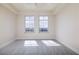 Bright bedroom with gray floors, two large windows, and natural light at 265 Minorca Beach Way # 505, New Smyrna Beach, FL 32169