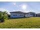 Lush backyard view with a covered patio perfect for outdoor entertaining with an abundance of sunlight at 2820 Neverland Dr, New Smyrna Beach, FL 32168