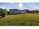 Expansive backyard featuring lush green grass and a covered patio area, perfect for outdoor entertaining at 2820 Neverland Dr, New Smyrna Beach, FL 32168