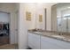 Bathroom with double vanity sinks, granite countertops, mirrors, walk-in shower, and walk-in closet at 2820 Neverland Dr, New Smyrna Beach, FL 32168