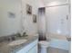 Bathroom with granite countertop vanity, decorative coastal-themed artwork, and shower with purple shower curtain at 2820 Neverland Dr, New Smyrna Beach, FL 32168