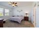 Bright bedroom with carpeted floors, ceiling fan, two windows, and a view to the bathroom at 2820 Neverland Dr, New Smyrna Beach, FL 32168