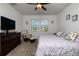 Bedroom featuring ceiling fan, dresser, sitting chair, and a picturesque view of the lake at 2820 Neverland Dr, New Smyrna Beach, FL 32168