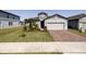 Well-maintained home featuring lush landscaping, brick driveway and a two-car garage at 2820 Neverland Dr, New Smyrna Beach, FL 32168
