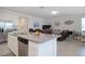 Open kitchen with island, granite countertops, stainless appliances, and seamless flow into the living room area at 2820 Neverland Dr, New Smyrna Beach, FL 32168