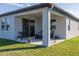 A covered patio with seating provides an inviting outdoor space to relax, sheltered from the elements at 2820 Neverland Dr, New Smyrna Beach, FL 32168