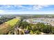 An aerial view of a home in a serene setting surrounded by lush greenery and a pond at 29 Promenade At Lionspaw, Daytona Beach, FL 32124