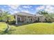 The back of the home has a covered patio and well-maintained lawn edged by garden plants at 29 Promenade At Lionspaw, Daytona Beach, FL 32124