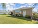 Rear exterior featuring a lush yard, picture window, access door, and mature landscaping at 29 Promenade At Lionspaw, Daytona Beach, FL 32124