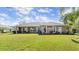 Back exterior displaying a covered patio, manicured lawn and flowering plants at 29 Promenade At Lionspaw, Daytona Beach, FL 32124