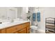 Bathroom featuring a wooden vanity with a marble countertop, toilet, decorative elements, and storage shelves at 29 Promenade At Lionspaw, Daytona Beach, FL 32124