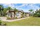 Charming single-story home featuring lush landscaping, mature palm trees, and a well-manicured lawn at 29 Promenade At Lionspaw, Daytona Beach, FL 32124