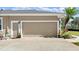 Spacious two-car garage with adjacent entry door and manicured potted plants and landscaping at 29 Promenade At Lionspaw, Daytona Beach, FL 32124