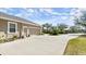 View of the home's 2-car garage and driveway accented by manicured greenery and landscaping at 29 Promenade At Lionspaw, Daytona Beach, FL 32124