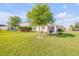 Large backyard with a paver patio, palm trees, and a well-maintained lawn at 2943 Gibraltar Blvd, New Smyrna Beach, FL 32168