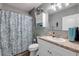 Well-lit bathroom with vanity, decorative shower curtain, and matching accessories at 2943 Gibraltar Blvd, New Smyrna Beach, FL 32168