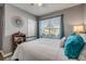 Cozy bedroom featuring a bright window, comfortable bed, and a stylish decorative mirror at 2943 Gibraltar Blvd, New Smyrna Beach, FL 32168