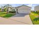 Welcoming home with a wide driveway, lush lawn, a palm tree, and tasteful landscaping at 2943 Gibraltar Blvd, New Smyrna Beach, FL 32168
