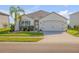 Charming single-story home with a well-manicured lawn, a two-car garage, and a palm tree at 2943 Gibraltar Blvd, New Smyrna Beach, FL 32168