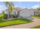 Inviting home with vibrant green lawn, mature landscaping, and a bench under a palm tree at 2943 Gibraltar Blvd, New Smyrna Beach, FL 32168