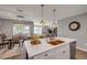 Open concept kitchen with island seating, quartz countertops, and stainless steel appliances overlooking the dining and living areas at 2943 Gibraltar Blvd, New Smyrna Beach, FL 32168