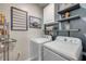 Well-organized laundry room with modern washer and dryer units and shelving for storage at 2943 Gibraltar Blvd, New Smyrna Beach, FL 32168