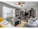 Cozy living room features hardwood floors, decorative shelving, a ceiling fan, and a large window providing natural light at 2943 Gibraltar Blvd, New Smyrna Beach, FL 32168