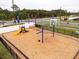 Community playground with swings, slide, and wood chip ground cover, fenced in at 2943 Gibraltar Blvd, New Smyrna Beach, FL 32168