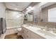 Well-lit bathroom with dual vanity, framed mirrors, and tiled walk-in shower at 315 N Causeway # C402, New Smyrna Beach, FL 32169
