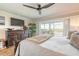 Bright bedroom with balcony, ceiling fan, dresser, and warm, neutral tones at 315 N Causeway # C402, New Smyrna Beach, FL 32169
