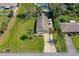 Aerial front view featuring well kept lawns, a two car driveway, and mature palm trees at 3403 Kumquat Dr, Edgewater, FL 32141