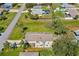 Back aerial view showcasing a cozy patio, mature trees, and spacious fenced backyard at 3403 Kumquat Dr, Edgewater, FL 32141