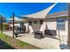 Outdoor patio with shade sails, stylish seating, and a sleek fire pit for entertaining guests at 3403 Kumquat Dr, Edgewater, FL 32141