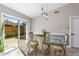Dining area featuring a glass-top table, stylish chairs, elegant pendant lighting, and sliding glass doors to the backyard at 3403 Kumquat Dr, Edgewater, FL 32141