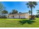 Charming single-story home featuring a well-maintained lawn, palm trees, and a classic American flag at 3403 Kumquat Dr, Edgewater, FL 32141