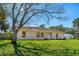 View of a charming single-story home with a large tree and a well-maintained lawn at 3403 Kumquat Dr, Edgewater, FL 32141