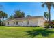 Charming single-story home boasts a well-manicured lawn, and a neatly landscaped yard with mature palm trees at 3403 Kumquat Dr, Edgewater, FL 32141