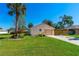 Beautifully landscaped home featuring mature palm trees, lush greenery, and a well-maintained lawn enhancing its curb appeal at 3403 Kumquat Dr, Edgewater, FL 32141