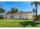 Well-maintained home exterior showcasing lush lawn, palm trees, and meticulously landscaped front yard at 3403 Kumquat Dr, Edgewater, FL 32141