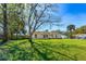 Well-maintained front lawn featuring mature trees, providing shade and enhancing the curb appeal of the property at 3403 Kumquat Dr, Edgewater, FL 32141